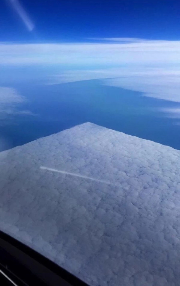 Huge cloud rectangles are visible from the plane.